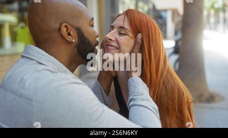 Couple interracial dans l'amour profite d'un moment tendre dans une rue de la ville représentant une relation urbaine chaleureuse entre un homme et une femme. Banque D'Images