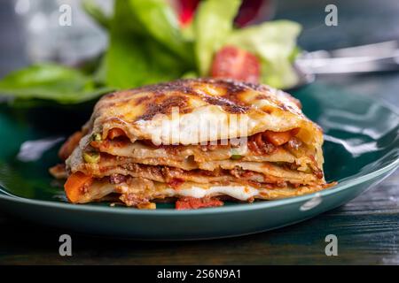 Lasagnes italiennes sur une assiette verte Banque D'Images