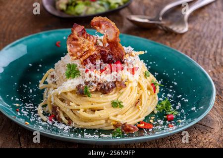 Spaghetti carbonara avec salade sur bois Banque D'Images