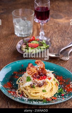 Spaghetti carbonara avec salade sur bois Banque D'Images
