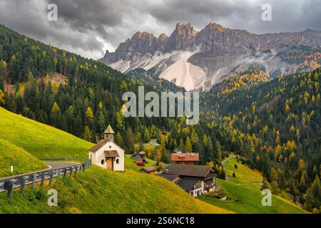 Une petite église avec la couleur du feuillage d'automne dans les arbres à Val di Funes près de Santa Magdalena, Italie, Europe. Banque D'Images