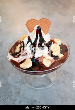 Un sundae au chocolat à la banane avec crème fouettée et sauce au chocolat Banque D'Images