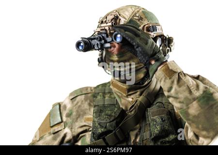 Vue rapprochée d'un soldat équipé d'un équipement tactique avancé, examinant à travers des lunettes de vision nocturne. Cadre professionnel avec backgrou blanc Banque D'Images
