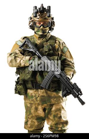 Un soldat militaire portant un camouflage, tenant un fusil, et vêtu de tout l'équipement tactique. L'individu porte également un casque avancé et nig Banque D'Images