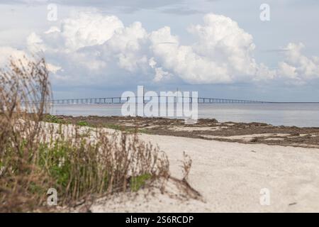 Vue du parc Fort de Soto au lever du soleil. Des teintes brillantes d'orange, de rose et de violet peignent le ciel, reflétant les eaux calmes sous Iconic Bridge Banque D'Images