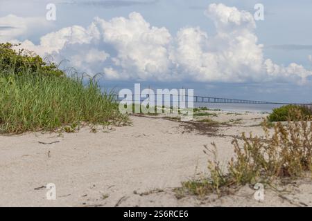 Vue du parc Fort de Soto au lever du soleil. Des teintes brillantes d'orange, de rose et de violet peignent le ciel, reflétant les eaux calmes sous Iconic Bridge Banque D'Images