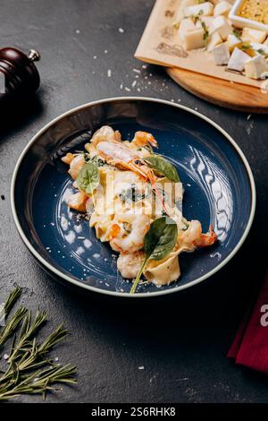 Pâtes gastronomiques aux crevettes en sauce crémeuse, magnifiquement plaquées pour une expérience culinaire gourmande Banque D'Images