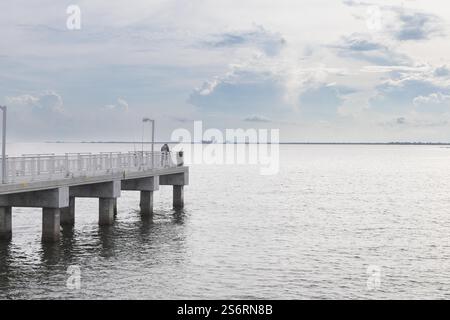 Vue du parc Fort de Soto au lever du soleil. Des teintes brillantes d'orange, de rose et de violet peignent le ciel, reflétant les eaux calmes sous Iconic Bridge Banque D'Images