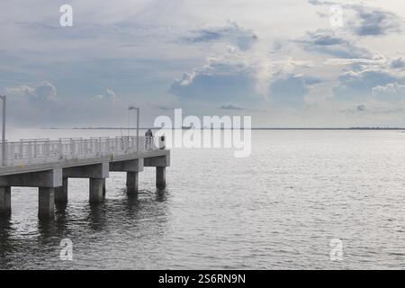 Vue du parc Fort de Soto au lever du soleil. Des teintes brillantes d'orange, de rose et de violet peignent le ciel, reflétant les eaux calmes sous Iconic Bridge Banque D'Images