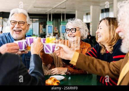 Heureux groupe de personnes âgées appréciant le café au bar cafétéria Banque D'Images