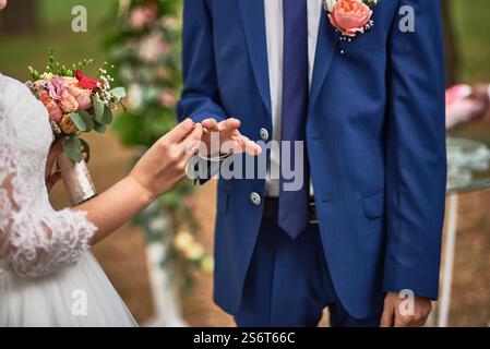 Mariée et mariée échangent des anneaux de mariage, un moment symbolique d'amour, dans une cérémonie romantique en plein air, habillé en tenue de mariage, orné de belle f Banque D'Images