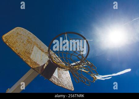 Vieux panier de basket rouillé contre la lumière Banque D'Images
