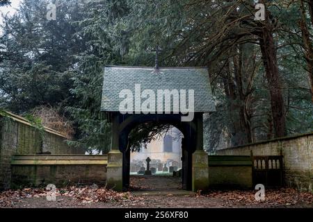 Lychgate entrant dans l'église All Saints dans la brume hivernale et le gel. Honington, Warwickshire, Angleterre Banque D'Images