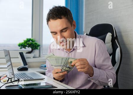 Homme d'affaires compte les billets de banque. Des mains d'homme qui considèrent les dollars américains. Dans les mains de beaucoup d'argent, coupures de 100 dollars. cent Banque D'Images