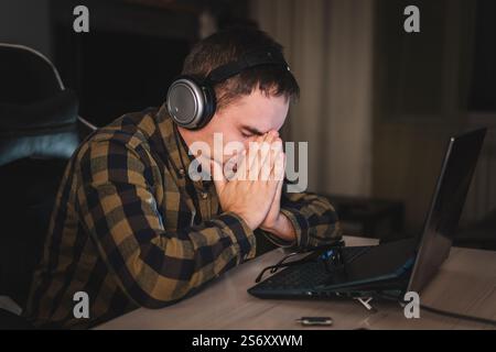 homme travaillant tenant mal à la tête du bureau travailler et assis toute la journée à l'aide d'un ordinateur portable souffrant de mal de tête travailleur malade concept de surmenage. œil Banque D'Images