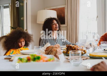Image narrative d'une famille réunie à la maison des parents pour le déjeuner sur les vacances. Membres de la famille célébrant à la maison manger de la bonne nourriture, partager l'amour Banque D'Images