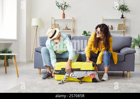 Jeune couple emballage valise pour les vacances d'été à la maison Banque D'Images