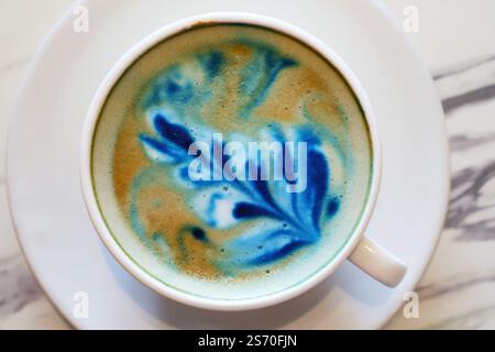 Café cappuccino appétissant avec motif papillons bleus Banque D'Images