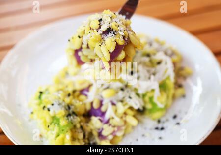 Dessert thaïlandais appétissant composé de boulettes de riz collant et de haricots mung saupoudrées de sucre et de graines de sésame appelé Khanom Tua Pap Banque D'Images