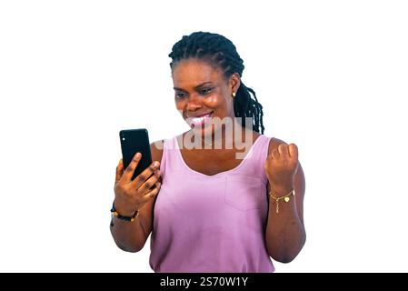 portrait d'une belle jeune femme heureuse utilisant un téléphone portable et faisant un geste gagnant avec la main levée. Banque D'Images