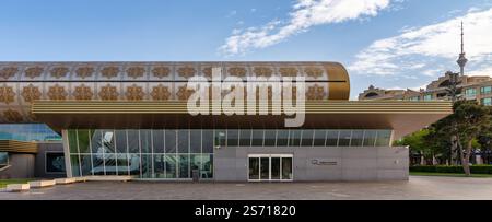 L'entrée du Musée national du tapis d'Azerbaïdjan présente son architecture unique sous un ciel bleu clair, avec la tour de télévision de Bakou en arrière-plan Banque D'Images