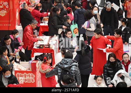 Tianjin. 18 janvier 2025. Adultes et enfants assistent à une foire du temple des enfants au Centre de la jeunesse et des enfants à Tianjin, au nord de la Chine, le 18 janvier 2025. L'événement pour enfants de trois jours a débuté samedi à Tianjin pour accueillir le nouvel an lunaire chinois en présentant le folklore du patrimoine culturel immatériel, des spectacles et des plats traditionnels. Crédit : Li Ran/Xinhua/Alamy Live News Banque D'Images