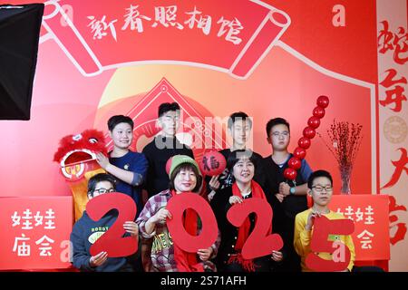 Tianjin. 18 janvier 2025. Adultes et enfants posent pour des photos lors d'une foire du temple des enfants au Centre de la jeunesse et des enfants à Tianjin, au nord de la Chine, le 18 janvier 2025. L'événement pour enfants de trois jours a débuté samedi à Tianjin pour accueillir le nouvel an lunaire chinois en présentant le folklore du patrimoine culturel immatériel, des spectacles et des plats traditionnels. Crédit : Li Ran/Xinhua/Alamy Live News Banque D'Images