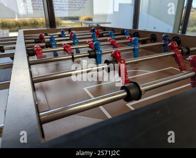Un portrait rapproché d'une table de baby-foot au niveau de la miniature plastique de football ou de joueurs de football dans un bar ou un café. ils sont prêts à être joués avec esprit Banque D'Images
