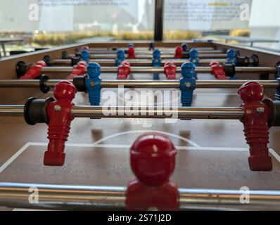 Un portrait rapproché d'une table de fussball au niveau du football en plastique miniature ou des joueurs de football dans un bar ou un café. ils sont prêts à être joués avec esprit Banque D'Images