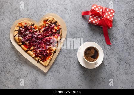 Nourriture pour la Saint-Valentin. Pizza maison douce en forme de coeur romantique, cadeau et café sur fond gris. Vue de dessus. Banque D'Images