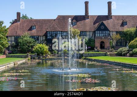 Woking Royaume-Uni - 13 août 2024 : deux femmes et enfants jouant à l'extérieur du bâtiment Old Laboratory et étang avec fontaine. Banque D'Images