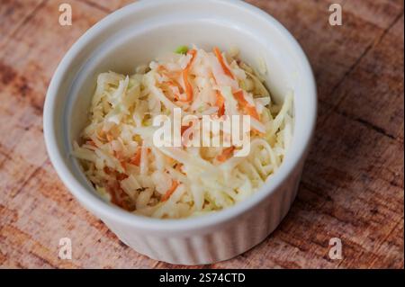 Coleslaw brillant et croquant fait avec du chou râpé et des carottes dans un bol. Banque D'Images