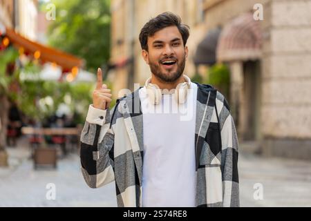 Eureka. Réfléchi intelligent inspiré homme indien faire le geste lève le doigt venu avec le plan créatif se sent excité avec la bonne idée inspiration motivation, question debout dans la rue de la ville. Styles de vie. Banque D'Images