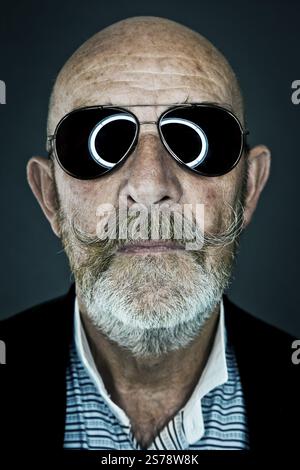 Un vieil homme avec une barbe grise portant des lunettes de soleil Banque D'Images