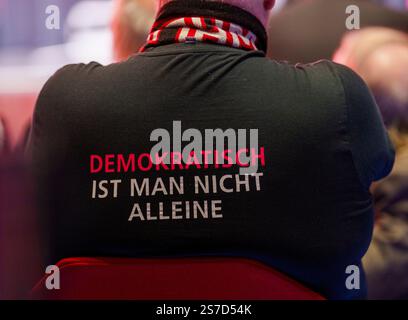 Schwalbach am Taunus, Allemagne. 19 janvier 2025. Lors de la campagne électorale du SPD avec le chancelier Scholz au Bürgerhaus, un participant porte un maillot «démocrate n'est pas seul». Le chancelier fédéral se rend en Hesse dans le cadre de la campagne électorale du Bundestag de 2025. Le centre communautaire de Schwalbach est complet. L'élection anticipée au Bundestag allemand est prévue pour le 23 février 2025. Crédit : Andreas Arnold/dpa/Alamy Live News Banque D'Images