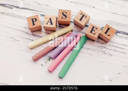 Craie colorée et pastel sur fond de bois blanc avec le mot Pastel, retour à shcool consept Banque D'Images