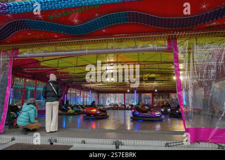 Iasi, Roumanie - 26 décembre 2024 : les gens visitent autodrome avec des voitures pare-chocs électriques colorées ou des voitures dodgem dans l'attraction au marché de Noël en c. Banque D'Images