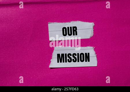 Notre message de mission écrit sur des morceaux de papier déchiré déchiré avec un fond rose. Conceptuel notre symbole de mission. Copier l'espace. Banque D'Images