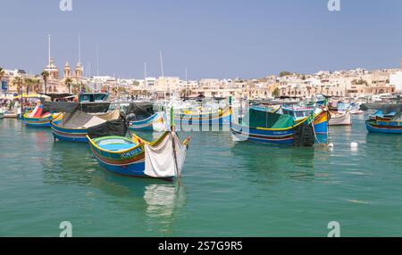Marsaxlokk, Malte - 28 août 2019 : des bateaux de pêche colorés sont ancrés au port de Marsaxlokk par une journée ensoleillée Banque D'Images