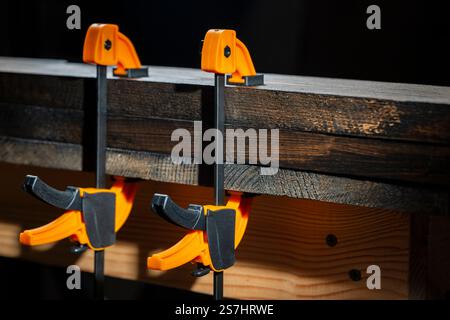 Charpentier deux pinces sont fixées aux planches, gros plan. Outils de menuiserie dans l'atelier de la maison Banque D'Images