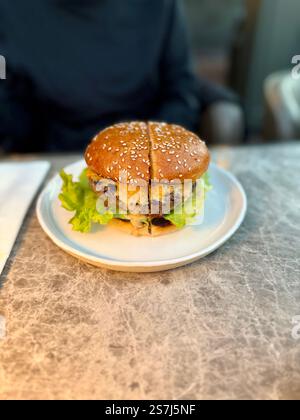 Hamburger cheeseburger servi avec assiette au restaurant. Prêt à manger Banque D'Images