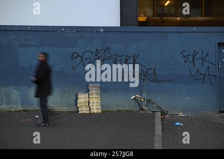 Scène urbaine avec Pro-Palestine Graffiti sur un mur et un piéton de passage Banque D'Images