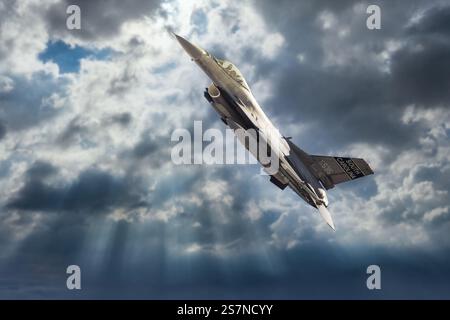 American Fighter Jet volant à travers des nuages spectaculaires Banque D'Images