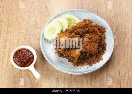 Ayam Goreng Lengkuas, poulet frit cuit avec des épices et saupoudré de galanga râpé. Cuisine traditionnelle indonésienne. Banque D'Images