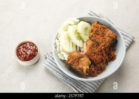 Ayam Goreng Lengkuas, poulet frit cuit avec des épices et saupoudré de galanga râpé. Cuisine traditionnelle indonésienne. Banque D'Images