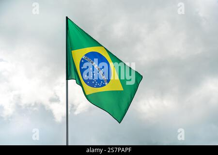 Drapeau sur le poteau de drapeau du Brésil et le ciel bleu drapeau du Brésil flottant dans le ciel bleu grand symbole national. Agitant le drapeau vert et jaune de l'État du Brésil, Indépendan Banque D'Images