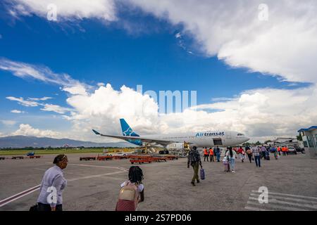 Les passagers montent à bord d'un vol Air Transat à partir du tarmac de l'aéroport de Port-au-Prince. Un moment de résilience et d’espoir pour les voyageurs. Banque D'Images