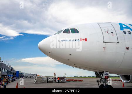 Un pilote d’Air Transat souriant fait des vagues depuis la fenêtre de son cockpit en attendant que des passagers montent à bord de son avion à l’aéroport de Port-au-Prince, en Haïti Banque D'Images