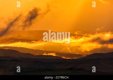 Coucher de soleil panoramique sur des collines ondulantes en silhouette Banque D'Images