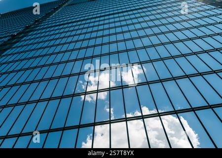 Mise au point sélective sur la haute clôture métallique verte avec des cellules rectangulaires contre le ciel nuageux. Banque D'Images